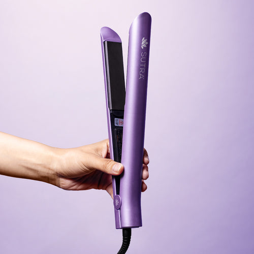 Hand-holding-lavender-ceramic-flat-iron-black-ceramic-plates-and-white-sutra-logo-on-a-purple-background