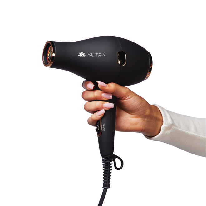 Hand-holding-black-infrared-bd2-blow-dryer-with-rose-gold-accents-white-sutra-logo-on-white-background